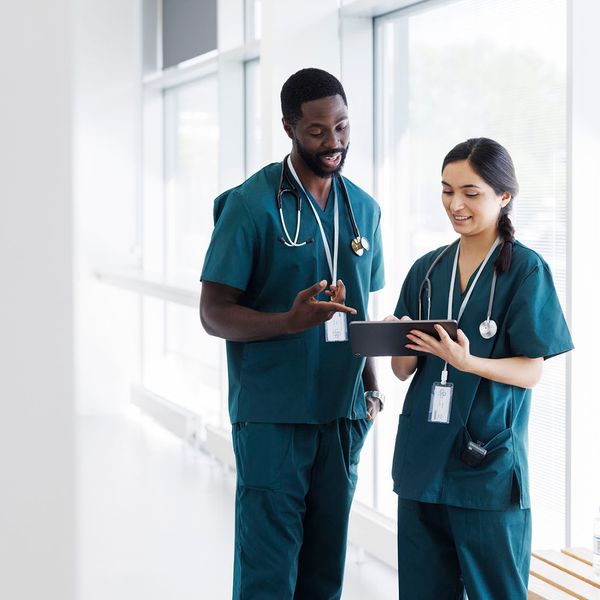 Two healthcare professionals looking at a tablet