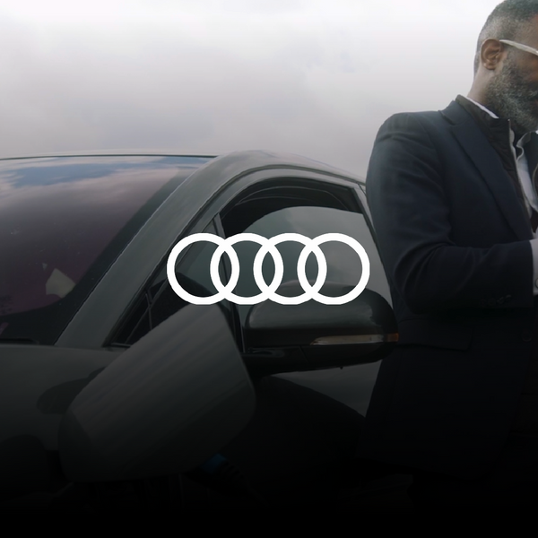 Black man charging his car while using his phone