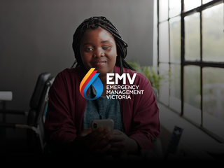 Visually impaired black woman holding phone and looking at the camera smiling