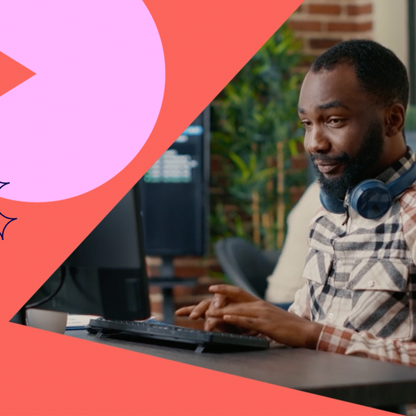 Desenvolvedor de software relaxado usando fones de ouvido sem fio sorrindo trabalhando olhando para a tela do computador