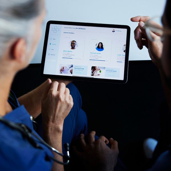 two doctors reading a content article at tablet