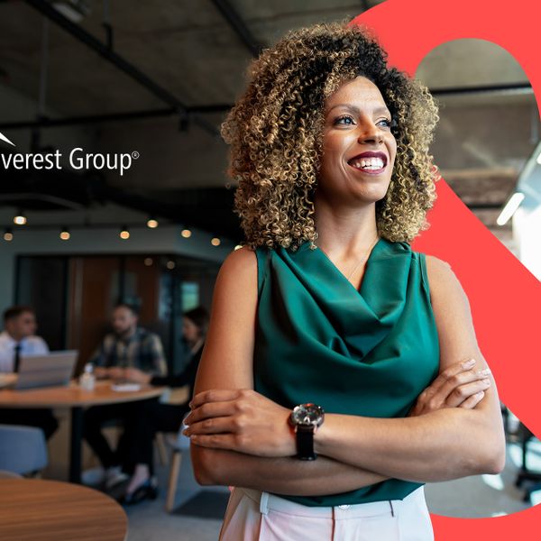A confident woman with curly hair, standing with her arms crossed and smiling. The logo of "Everest Group" is prominently displayed in the upper left corner, and a large red ampersand symbol is partially visible on the right side.