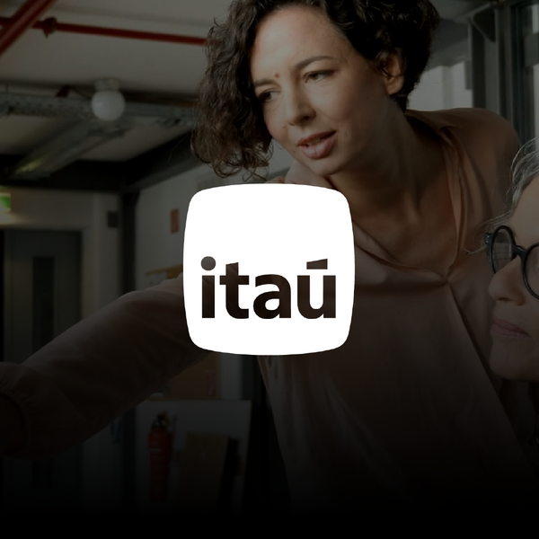 Ita&uacute; logo in white, and as background, an image of two women working together on a computer.