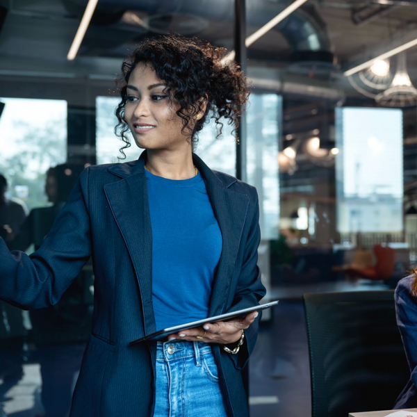 A female marketeer is on a presenting a market data on a digital display to make decision for new products launch with her team in a business office.
