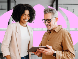 businesswoman and a senior male colleague collaboratively review content on a tablet
