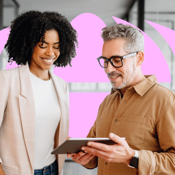 businesswoman and a senior male colleague collaboratively review content on a tablet