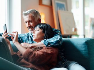 A couple looking through their phone together in a home setting