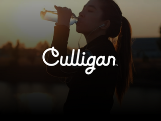 Woman in sports gear drinking from a waterbottle