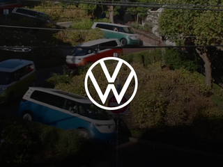 Several colorful Volkswagen cars driving down a hill