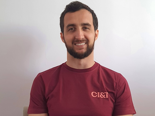 Felipe, homem branco de cabelo preto curto e barba preta curta, est&aacute; sorrindo e veste camisa bord&ocirc;.