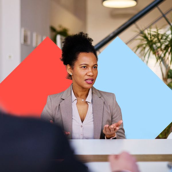 Businesswoman sitting at a table, leading a meeting with colleagues in a modern office