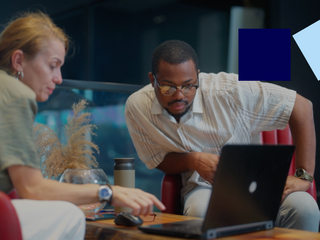 A businessman is meeting with a businesswoman in a modern office working space.