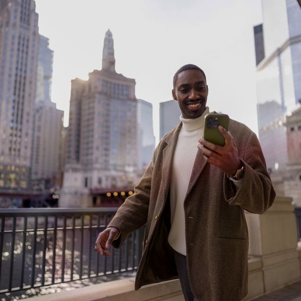 black businessman using smartphone at street in big city