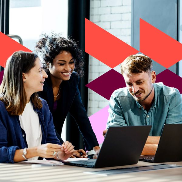 Three diverse colleagues—two women and one man—smile and collaborate around laptops in a bright, modern office setting, overlaid with vibrant geometric graphics.