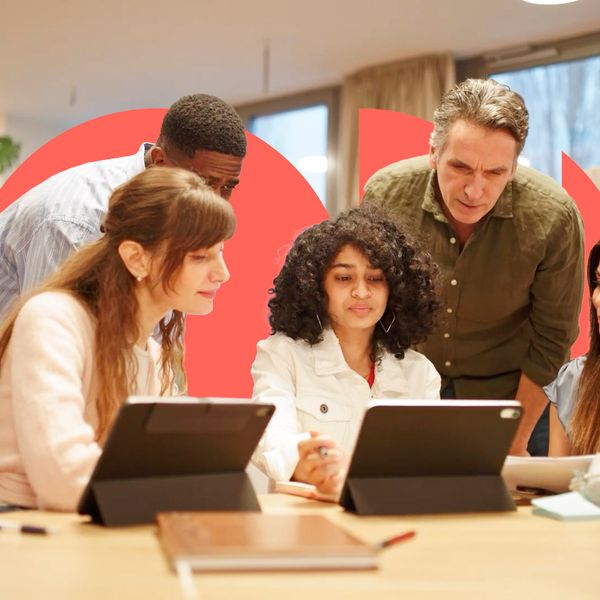 A diverse group of five colleagues collaborating around a table with tablets in a modern office, framed by large coral-colored geometric shapes in the background.