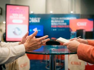 Two people talking at a CI&T conference booth