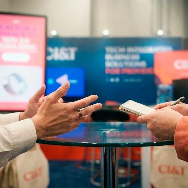 Two people talking at a CI&T conference booth