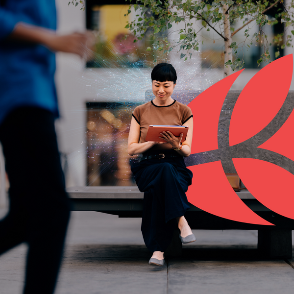 businesswoman sits on a bench in a city environment, using a digital tablet