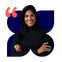 Ingrid, mulher parda de cabelo preto liso na altura dos ombros e olhos pretos, sorri. Ela est&aacute; de bra&ccedil;os cruzados e veste blusa preta.