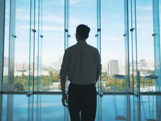 businessmen walking and looking out of window