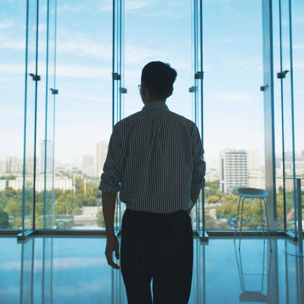 businessmen walking and looking out of window