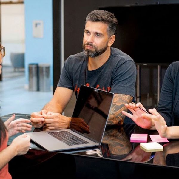 Three people talking at a CI&T office