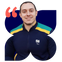 Daniel, homem branco de cabelo preto curto, sorrindo, veste um casaco azul marinho com a bandeira do Brasil e listras verde e amarelo.